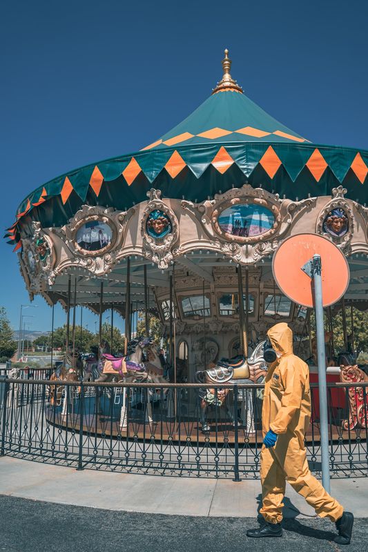 A figure in yellow in front of a carousel