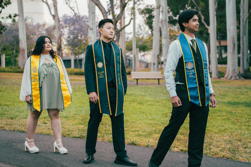 Three graduates walking together on campus