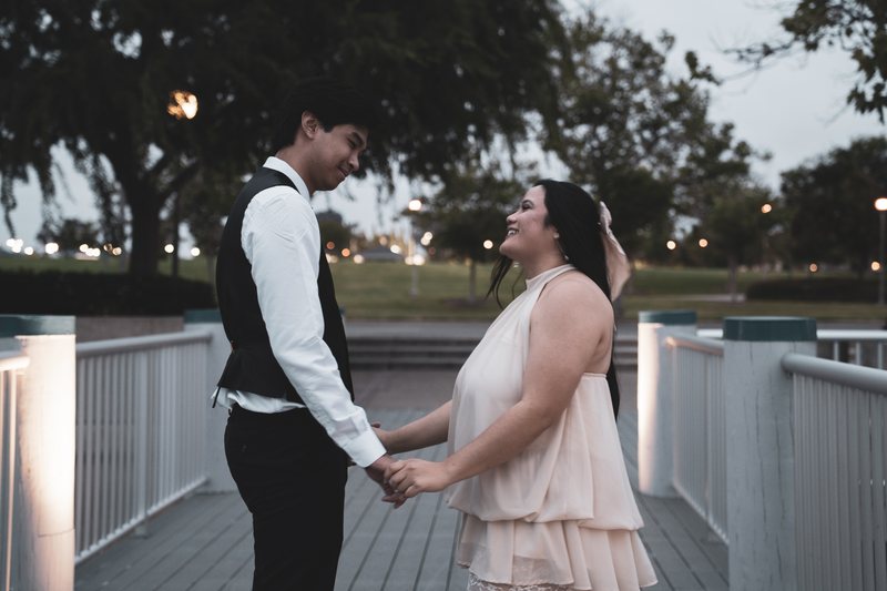 A couple laughing while holding hands on the boardwalk