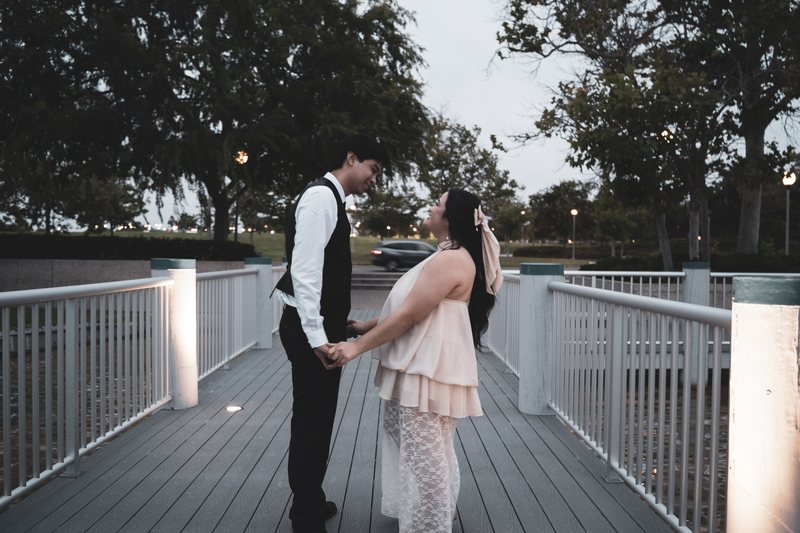 A couple facing each other between lit railings